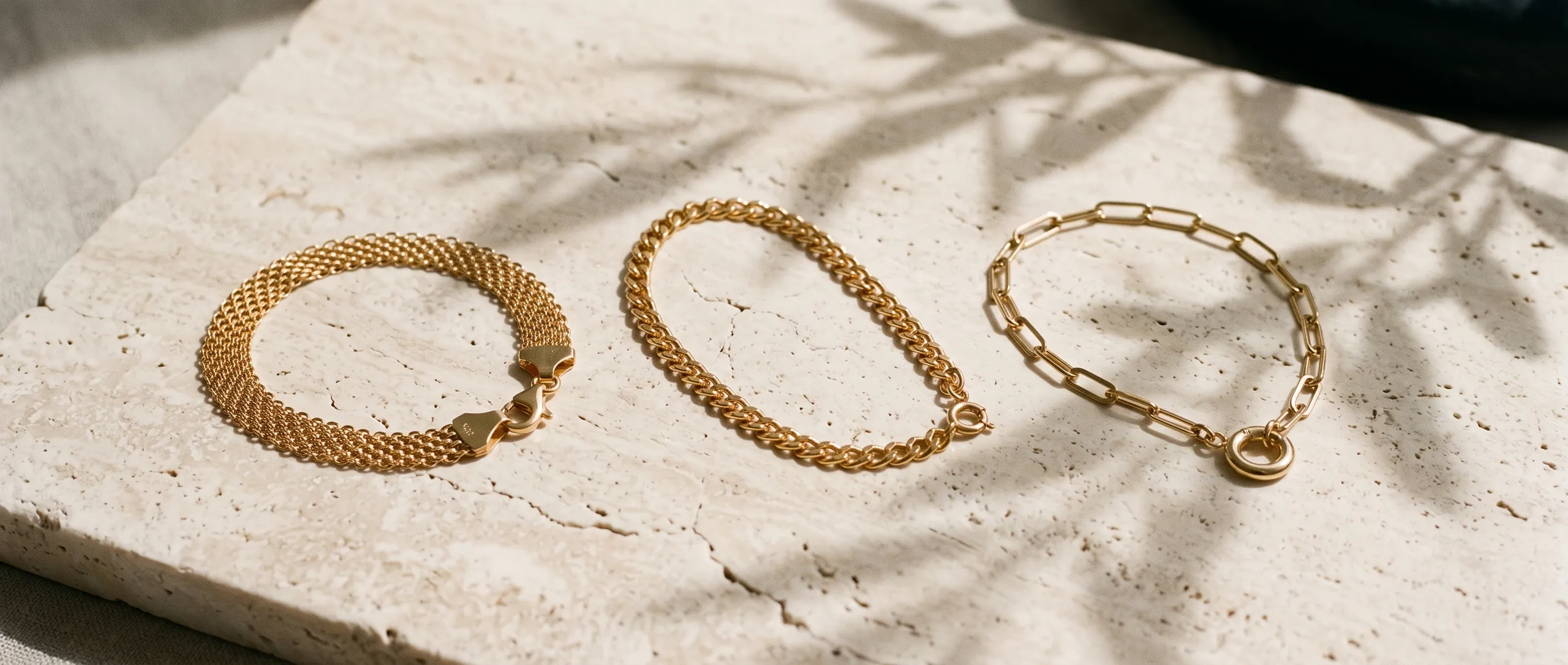 Tres pulseras de oro sobre travertino